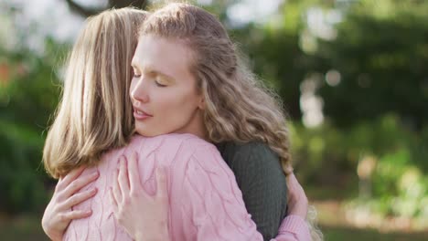Video-of-smiling-caucasian-adult-daughter-and-senior-mother-hugging-in-garden