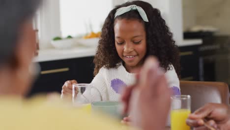 Video-De-Una-Feliz-Hija-Afroamericana-Riéndose-Y-Comiendo-Con-La-Familia-En-La-Mesa
