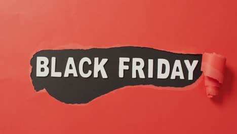 Ripped-red-paper-with-black-friday-text-in-white-on-red-background
