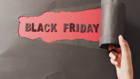 Ripped-black-paper-with-black-friday-text-in-black-on-red-background