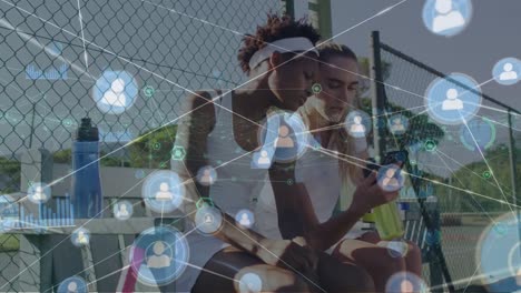 Animation-of-network-of-connections-with-icons-over-diverse-people-playing-tennis