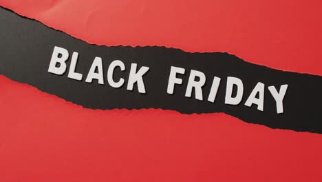 Black-Friday-Text-In-Weiß-Auf-Geripptem-Schwarzem-Querstreifen-Auf-Rotem-Hintergrund