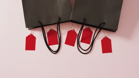 Zwei-Schwarze-Geschenktüten-Mit-Fünf-Roten-Verkaufsetiketten-Auf-Weißem-Hintergrund-Mit-Kopierraum