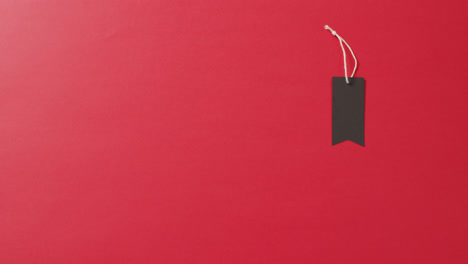 Schwarzes-Verkaufsetikett-Mit-Schnur-Auf-Rotem-Hintergrund-Mit-Kopierraum