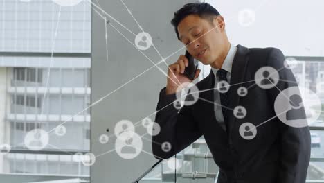 Animation-of-network-of-connections-over-biracial-businessman-using-smartphone
