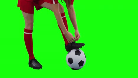 Video-Einer-Kaukasischen-Fußballspielerin,-Die-Schnürsenkel-Bindet-Und-Platz-Auf-Einem-Grünen-Bildschirm-Kopiert