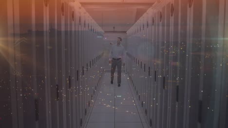 Composite-video-of-caucasian-male-engineer-walking-in-server-room-against-night-city-traffic