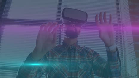Animation-of-blue-and-pink-light-trails-moving-over-biracial-man-wearing-vr-headset-at-office