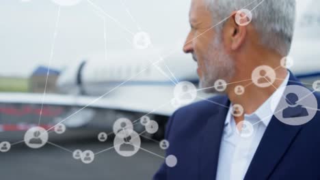 Animation-of-network-of-profile-icons-over-caucasian-senior-businessman-standing-at-the-airport