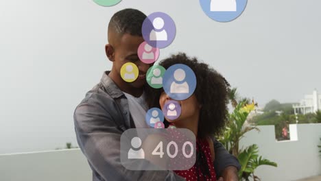 Animation-of-profile-icons-with-increasing-numbers-over-african-american-couple-hugging-each-other