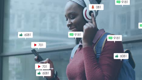 Animation-of-social-media-icons-with-growing-numbers-over-african-american-woman-using-smartphone