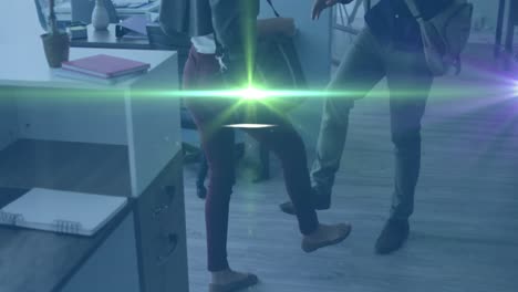 Animation-of-green-light-spot-over-diverse-man-and-woman-greeting-by-touching-their-feet-at-office