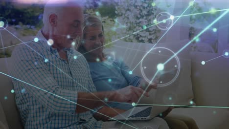 Animation-of-network-of-connections-with-light-trails-over-senior-caucasian-couple-using-laptop