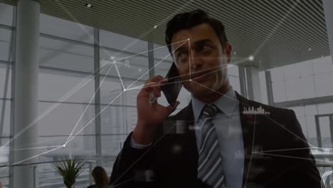 Animation-of-network-of-connections-over-caucasian-businessman-talking-on-smartphone-at-office