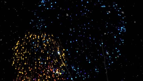 Animation-of-white-particles-over-colorful-fireworks-exploding-against-black-background