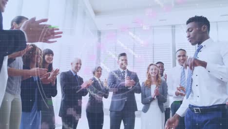 Animation-of-dna-helix-with-circles-over-diverse-colleagues-applauding-for-man-dancing-in-office