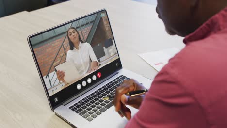 Animation-of-african-american-man-having-video-call-on-laptop