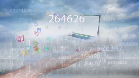 Animation-of-cropped-hand-holding-laptop-on-cloud-with-numbers,-icons-over-cityscape-in-sky