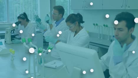 Animation-of-floating-white-dots-over-caucasian-scientists-doing-research-in-laboratory