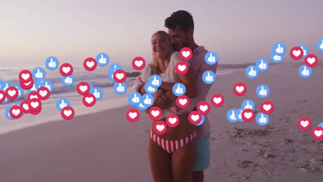 Animation-of-falling-social-media-icons-over-caucasian-couple-walking-on-the-beach