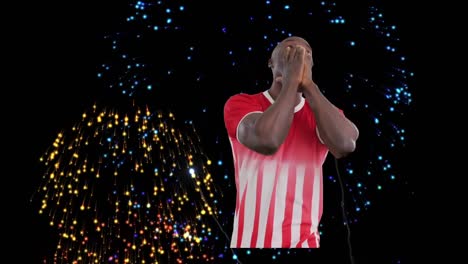 Animation-of-fireworks-over-african-american-male-soccer-player-smiling