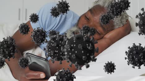Animation-of-virus-cells-over-african-american-man-lying-in-bed-and-using-smartphone