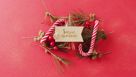 Video-of-christmas-decoration-with-seasons-greetings-text-on-tag-on-red-background