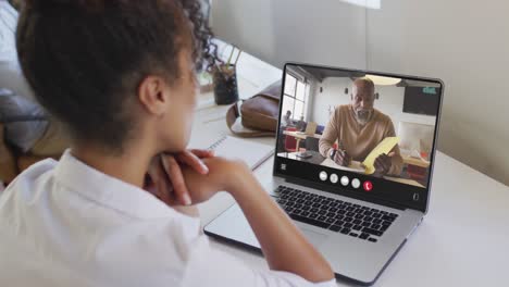 African-american-woman-using-laptop-for-video-call,-with-business-colleague-on-screen