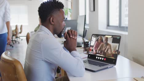 Hombre-Afroamericano-Usando-Una-Computadora-Portátil-Para-Videollamadas,-Con-Diversos-Colegas-De-Negocios-En-La-Pantalla