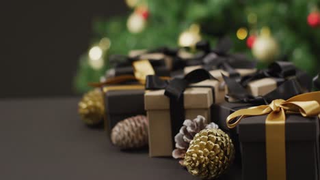 Video-of-christmas-gifts-with-pine-cones-and-copy-space-on-black-background