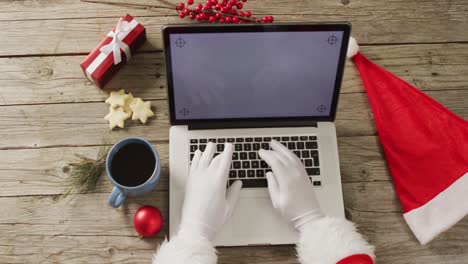 Santa-claus-using-laptop-with-copy-space-over-christmas-decorations