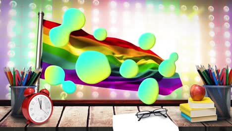 Animation-Grüner-Formen-über-LGBT-Flagge-Und-Schreibtisch