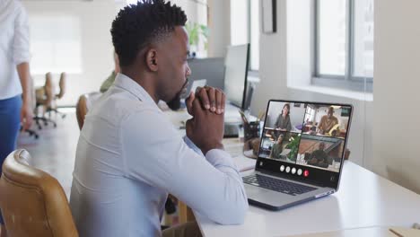Afroamerikanischer-Mann-Nutzt-Laptop-Für-Videoanrufe,-Mit-Verschiedenen-Geschäftskollegen-Auf-Dem-Bildschirm