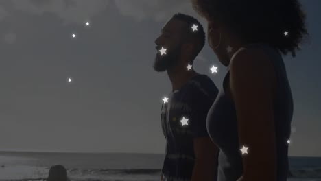 Animation-Von-Sternen-über-Einem-Vielfältigen-Paar-Am-Strand