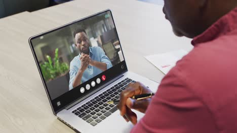 Hombre-Afroamericano-Usando-Una-Computadora-Portátil-Para-Videollamadas,-Con-Un-Colega-De-Negocios-En-La-Pantalla