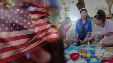 Animation-of-flag-of-usa-over-diverse-group-of-friends-having-party-outdoors