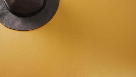Video-of-close-up-of-hat-on-yellow-background
