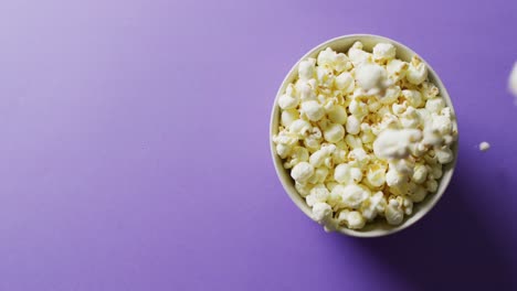 Video-of-close-up-of-popcorn-on-purple-background