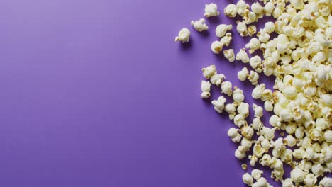 Video-of-close-up-of-popcorn-on-purple-background
