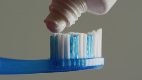 Video-of-close-up-of-toothbrush-and-paste-on-gray-background
