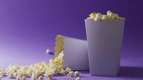 Video-of-close-up-of-popcorn-falling-on-blue-background