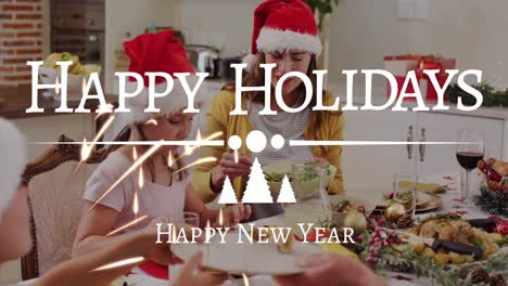 Animation-of-happy-holidays-and-new-year-text-in-white-over-family-in-santa-hats-at-dinner-table