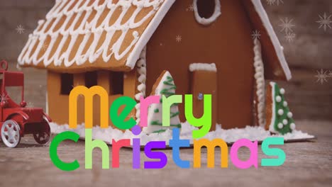 Animation-of-merry-christmas-in-colourful-text-with-snowflakes-over-gingerbread-house