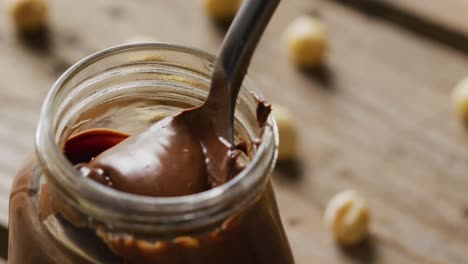 Video-of-close-up-of-jar-of-chocolate-cream-on-white-background