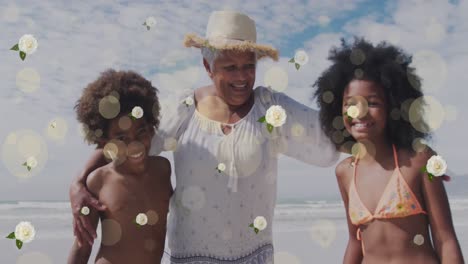 Animation-Von-Flecken-Und-Blumen-über-Glücklicher-Afroamerikanischer-Großmutter-Und-Enkelkindern-Am-Strand