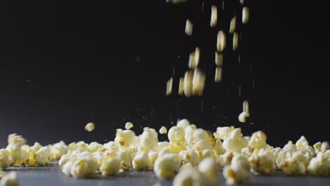Video-of-close-up-of-popcorn-falling-on-black-background