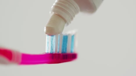 Video-of-close-up-of-toothbrush-and-paste-on-white-background