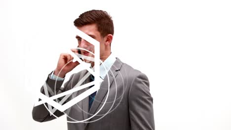 Animation-of-abstract-triangular-shape-spinning-over-caucasian-businessman-talking-on-smartphone