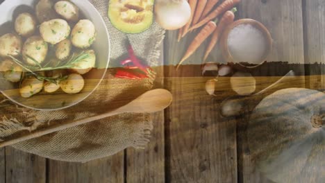 Animation-of-landscape-over-plates-with-food-on-wooden-background