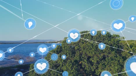 Animation-of-network-of-digital-icons-over-aerial-view-of-island-and-ocean